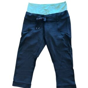 Lululemon black cropped athletic leggings featuring a contrasting mint waistband